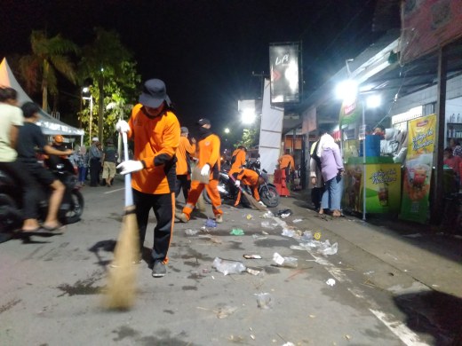 Petugas kebersihan dari DLH Tanjung Jabung Barat membersihkan sampah yang ditinggalkan warga usai menyaksikan Festival Arakan Sahur, Sabtu (1/4/23) Malam. FOTO : LT 