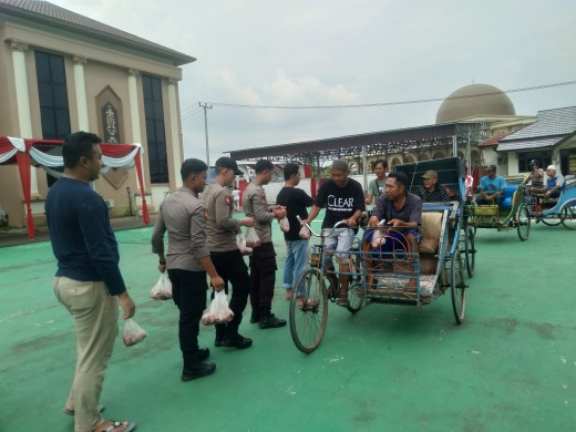 Personel Polres Tanjung Jabung Barat membagikan Daging Kurban kepada Para Tukang Becak di Halaman Mapolres, Kamis (29/6/23). FOTO : LT