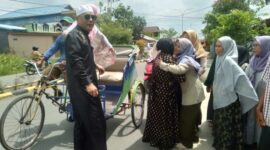 H. Syafrizal Lubis dan Istri Disambut Warga saat perjalanan menuju Rumah dengan menumpangi Becak. FOTO : LT