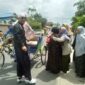 H. Syafrizal Lubis dan Istri Disambut Warga saat perjalanan menuju Rumah dengan menumpangi Becak. FOTO : LT