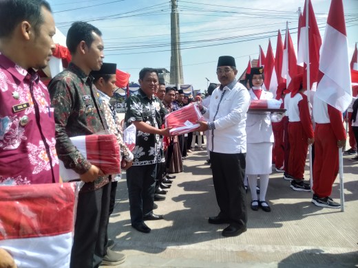 Bupati Tanjung Jabung Barat H Anwar Sadat secara simbolis membagikan Bendera Merah Putih yang dibawa Paskibraka kepada Para Camat, Rabu (2/8/23). FOTO : LT 