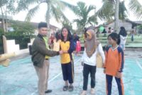 Erham, S. Ag menyerahkan Hadiah Hiburan kepada Anak-Anak Pemenang Lomba di RT 009 Patunas, Sabtu (26/8/23). FOTO : LT