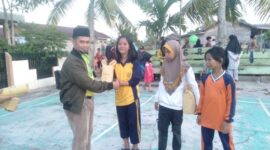 Erham, S. Ag menyerahkan Hadiah Hiburan kepada Anak-Anak Pemenang Lomba di RT 009 Patunas, Sabtu (26/8/23). FOTO : LT
