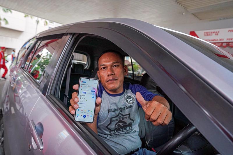 Seorang pemudik menunjukkan aplikasi MyPertamina dari dalam kendaraannya saat melakukan pengisian BBM di SPBU Pertamina, Kamis (26/3). Melalui aplikasi ini, Pertamina Patra Niaga memberikan berbagai promo spesial Lebaran 2026, termasuk diskon Pertamax hingga Rp15.000 untuk mendukung perjalanan mudik yang lebih hemat. (FOTO : Dok. Istimewa)