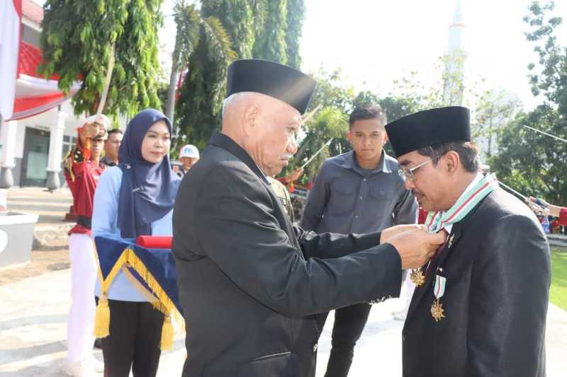 Prof Dr Drs H Ermaya Suradinata, S. H., M. H., M. S berikan penghargaan kepada Bupati Tanjab Barat Drs H Anwar Sadat, M. Ag. FOTO : Prokopim 