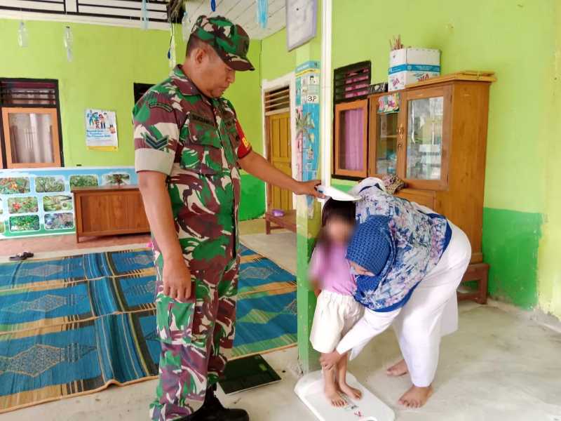 Babinsa Rantau Badak Koramil 419-01/Muara Sabak Kodim 0419/Tanjab Sertu Sugianto dampingi Petugas Posyandu saat ukur Tinggi Badan seorang Anak. FOTO : Pentjb