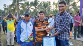 Camat Kuala Betara Badai Permana menyerahkan Tropi dan Uang Pembinaan kepada Kapten dan Tim Manager Kesebelasan Desa Suak Labu Juara III Camat Cup Kuala Betara. FOTO : LT