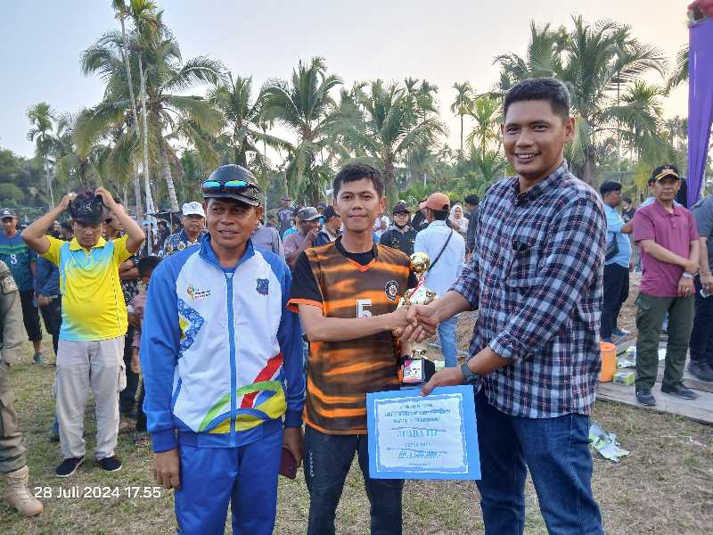 Camat Kuala Betara Badai Permana menyerahkan Tropi dan Uang Pembinaan kepada Kapten dan Tim Manager Kesebelasan Desa Suak Labu Juara III Camat Cup Kuala Betara. FOTO : LT