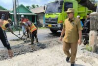 Bupati Tanjab Barat Drs H Anwar Sadat, M. Ag pantau langsung pengaspala Jalan Lintas Jambi-Kualatung di Sungai Saren. FOTO : Ist