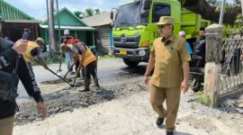 Bupati Tanjab Barat Drs H Anwar Sadat, M. Ag pantau langsung pengaspala Jalan Lintas Jambi-Kualatung di Sungai Saren. FOTO : Ist