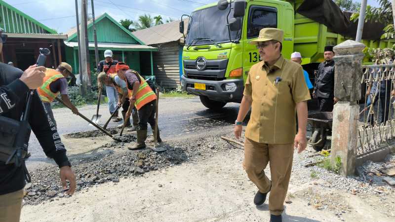 Bupati Tanjab Barat Drs H Anwar Sadat, M. Ag pantau langsung pengaspala Jalan Lintas Jambi-Kualatung di Sungai Saren. FOTO : Ist