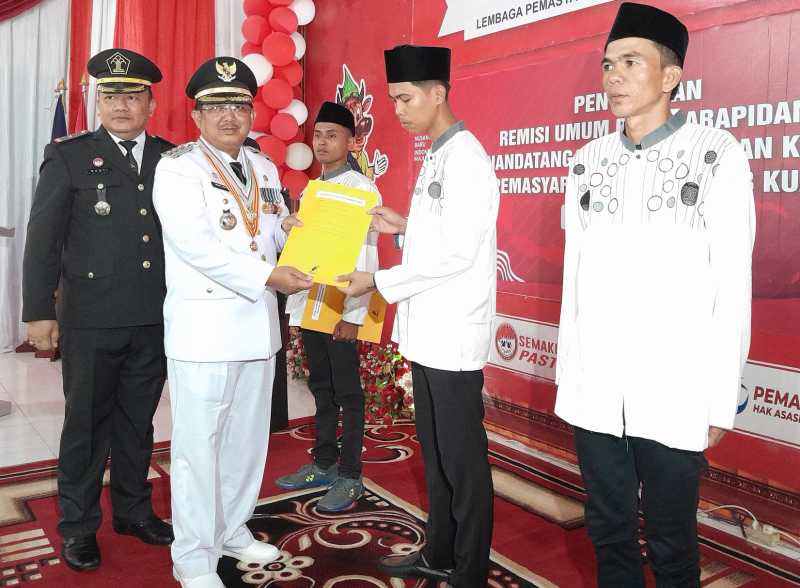 Bupati Tanjab Barat H Anwar Sadat didampingi Kalapas Kelas IIB Kuala Tungkal I Gusti Lanang ACP saat menyerahkan SK Remisi. FOTO : Humas