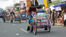 Peserta saat memacu Becak dalam Lomba Balap Becak Hias. FOTO : Asri Pct