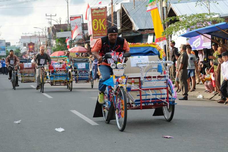 Peserta saat memacu Becak dalam Lomba Balap Becak Hias. FOTO : Asri Pct