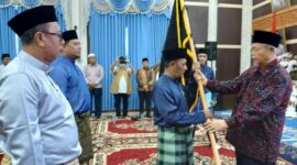 H Facruddin Razi menyerahkan Pataka KMJKS kepada Ketua Cabang KMJKS Tanjab Barat Muhammad Firdaus disela acara pengukuhan.