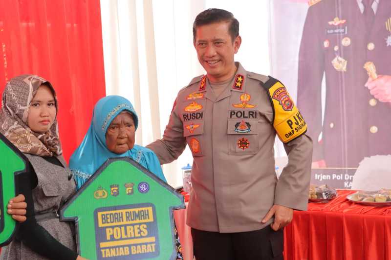 Kapolda Jambi Irjen Pol Rusdi Hartono menyerahkan Kunci Rumah kepada Ibu Minah penerima Progrqm Bedah Rumah Polres Tanjab Barat. (Dok Humas)