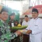 Bupati Drs H Anwar Sadat, M. Ag menerima potongan tumpeng saat peringatan Harlah dan Mulimat NU (Prokopim)
