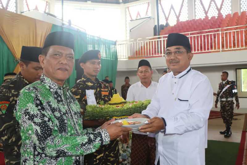 Bupati Drs H Anwar Sadat, M. Ag menerima potongan tumpeng saat peringatan Harlah dan Mulimat NU (Prokopim)