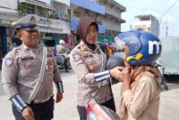 Didampingi Anggota, Kasatlantas Polres Tanjab Barat AKP Rita Purnama Sari bagikan Helm ke Warga saat Patroli Edukasi (Dok LT)