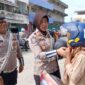 Didampingi Anggota, Kasatlantas Polres Tanjab Barat AKP Rita Purnama Sari bagikan Helm ke Warga saat Patroli Edukasi (Dok LT)