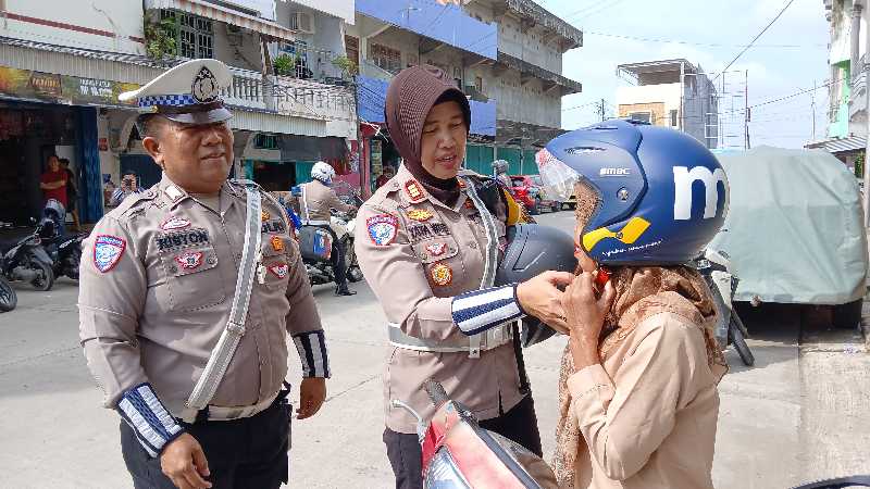 Didampingi Anggota, Kasatlantas Polres Tanjab Barat AKP Rita Purnama Sari bagikan Helm ke Warga saat Patroli Edukasi (Dok LT)