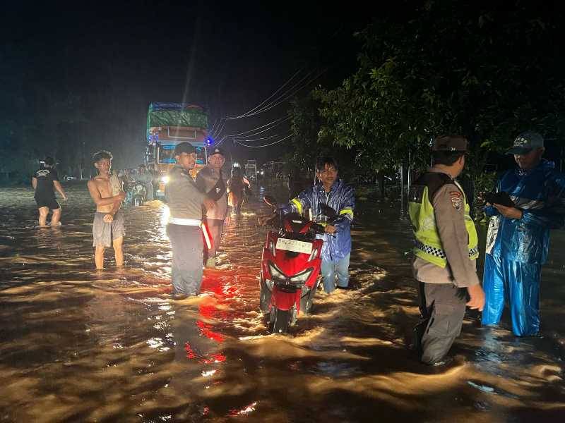 Anggota Polsek Tungkal Ulu dan BKO Satlantas Polres Tanjab Barat Saat Mengatur Lalu Lintas di Jalan Terendam Banjir (Polsek Tungkal Ulu)