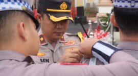 Wakapolres Tanjab Barat Kompol Johan Christy Silaen, S. I. K., M. H memasang tanda pita operasi kepada petugas (Humas)