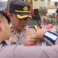 Wakapolres Tanjab Barat Kompol Johan Christy Silaen, S. I. K., M. H memasang tanda pita operasi kepada petugas (Humas)