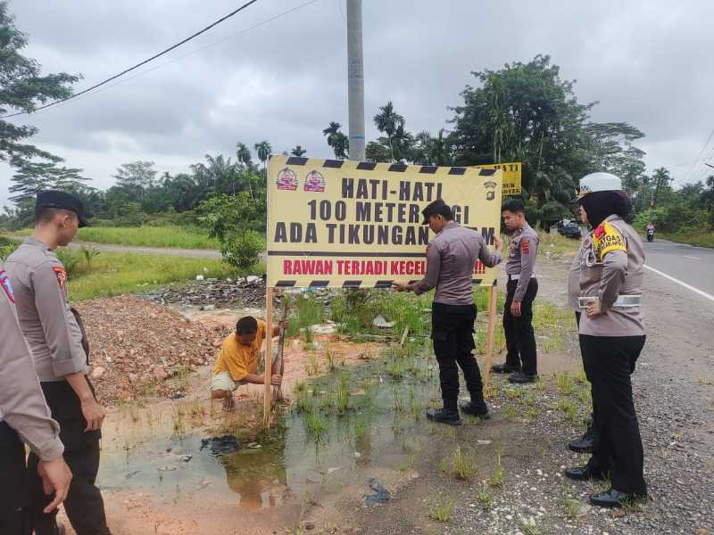 Personil Polres Tanjab Barat saat melakukan pemasangan spanduk Himbauan di Jalan Lintas Kuala Tungkal-Jambi (Humas)