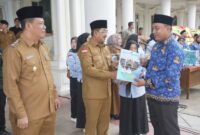 Didampingi Wabup Katamso, Bupati Tanjab Barat Anwar Sadat Serahkan SK kepada salah seorang ASN (Pro)