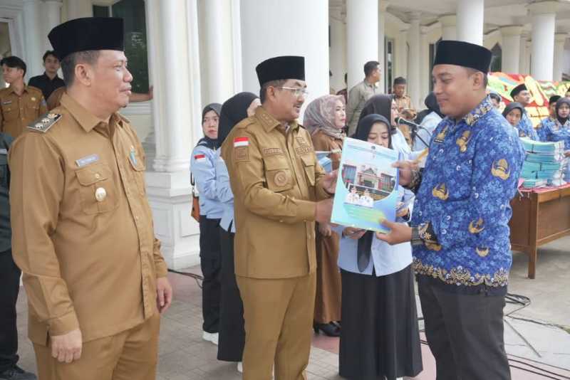 Didampingi Wabup Katamso, Bupati Tanjab Barat Anwar Sadat Serahkan SK kepada salah seorang ASN (Pro)