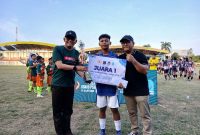 Staf Ahli Bupati H Angsori didampingi Ketua ASKAB PSSI Tanjab Barat Endri Avian serahkan Tropi Juara I Piala Soeratin 2025 U15 Grappipur (Humas)