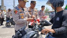 Kapolres Tanjab Barat AKBP Agung Basuki Memasang Bendera Merah Putih ke Kendaraan Warga (Ist)