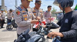 Kapolres Tanjab Barat AKBP Agung Basuki Memasang Bendera Merah Putih ke Kendaraan Warga (Ist)