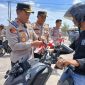 Kapolres Tanjab Barat AKBP Agung Basuki Memasang Bendera Merah Putih ke Kendaraan Warga (Ist)