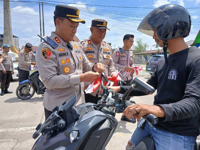 Kapolres Tanjab Barat AKBP Agung Basuki Memasang Bendera Merah Putih ke Kendaraan Warga (Ist)