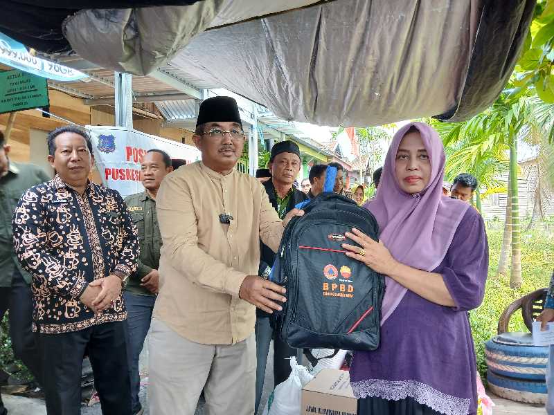 Bupati Tanjab Barat Anwar Sadat didampingi Kalaksa BPBD dan OPD terkait saat menyerahkan bantuan perlengkapan Sekolah Korban terdampak kebakaran (ist)
