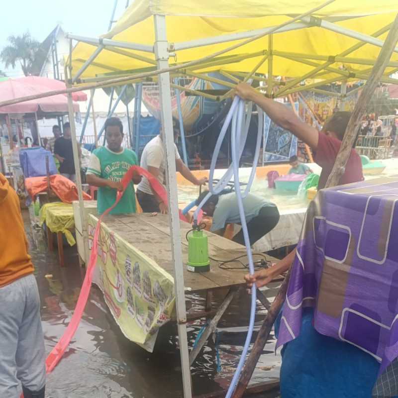 Pengurus PKL-UM Saat Membersihkan Genangan Air Hujan di Area Lapak Pedagang (mc)