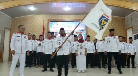 Ketua DPC Apdesi Tanjab Barat Abdul Gani Kibarkan Pataka Usai Dikukuhkan (ist)