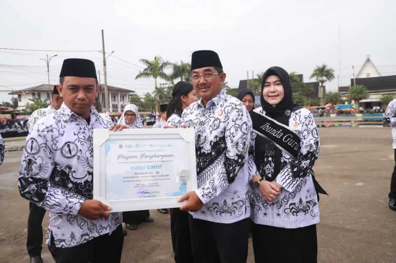 Didampingi Ibunda Guru Hj Fadhilah Sadat Bupati Tanjab Barat H Anwar Sadat Serahkan Piagam Penghargaan (pro)