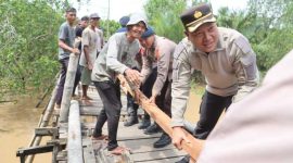 Bersama Warga, Kapolres Tanjab Barat AKBP Agung Basuki dan Personel Gotong Royong Perbaiki Jenbatan (hms)