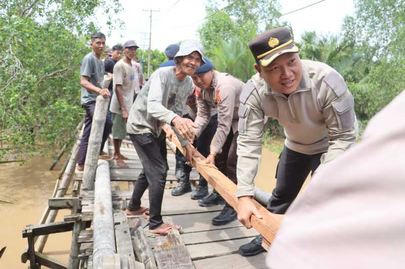 Bersama Warga, Kapolres Tanjab Barat AKBP Agung Basuki dan Personel Gotong Royong Perbaiki Jenbatan (hms)