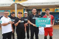 Sekda Tanjab Barat Hermansyah Menyerahkan Tropi Kepada Kapten Tim SMAN 9 Juara I JSFL 2025 (pro)