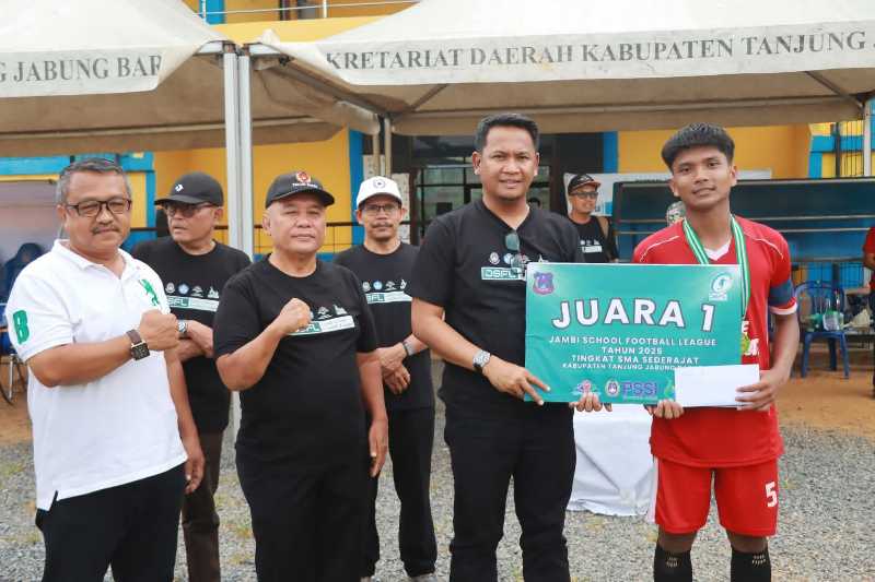Sekda Tanjab Barat Hermansyah Menyerahkan Tropi Kepada Kapten Tim SMAN 9 Juara I JSFL 2025 (pro)