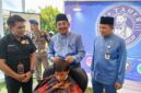 Bupati Tanjab Barat Anwar Sadat Didampingi Kepala Dinas Tenaga Kerja Dedy Ardiansyah Saat Kegiatan Pangkas Rambut (ist)