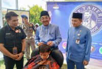 Bupati Tanjab Barat Anwar Sadat Didampingi Kepala Dinas Tenaga Kerja Dedy Ardiansyah Saat Kegiatan Pangkas Rambut (ist)