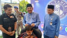 Bupati Tanjab Barat Anwar Sadat Didampingi Kepala Dinas Tenaga Kerja Dedy Ardiansyah Saat Kegiatan Pangkas Rambut (ist)