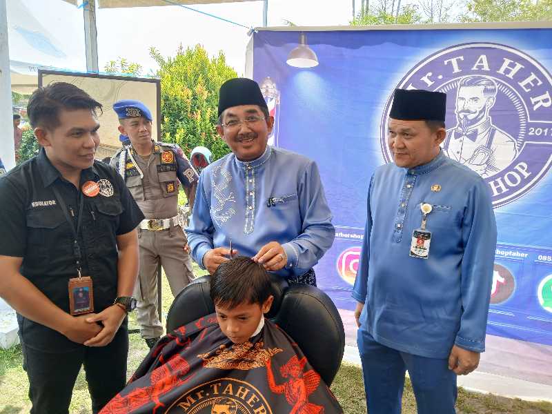 Bupati Tanjab Barat Anwar Sadat Didampingi Kepala Dinas Tenaga Kerja Dedy Ardiansyah Saat Kegiatan Pangkas Rambut (ist)