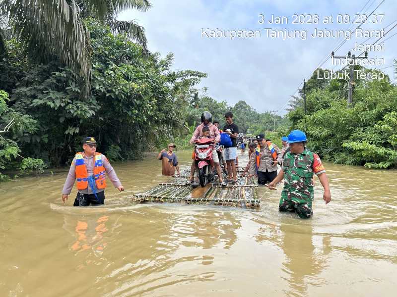 Kapolsek Merlung AKP Agung Heru Wibowo Bersama Personel dan Babinsa Bantu Warga Lewati Genangan Banjir di Lubuk Terap Gunakan Rakit (ist)