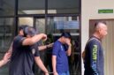 Dua terdakwa kasus penyelundupan 58 kilogram sabu, Agit Putra Ramadhan dan Juniardo alias Ardo, tampak menutupi wajah mereka dengan tangan saat digiring keluar dari ruang sidang Pengadilan Negeri Jambi usai mendengarkan tuntutan hukuman penjara seumur hidup dari Jaksa Penuntut Umum. (FOTO : Dok. Istimewa/jambiekspres.disway.id)